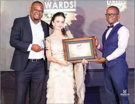  ?? ?? WestPro chief executive Ken Sharpe’s wife Joanna (centre) receiving an award on behalf of her husband. She is flanked by Megafest CEO Tafadzwa Matsika (left) and entreprene­ur Shingi Munyeza.