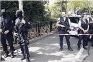  ??  ?? French hooded police officers guard the area with other police officers after a knife attack yesterday in Trappes, west of Paris.