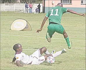  ?? (Pic: Sanele Jele) ?? Manzini Wanderers’ Menzi Mamba tackles Green Mamba’s Njabulo Magagula during a game played at Prince of Wales Sports Ground on Saturday.