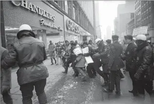  ?? JOURNAL SENTINEL FILES ?? John Ahlhauser made this photo of people participat­ing in a civil rights demonstrat­ion on Wisconsin Ave. on April 13, 1965. The demonstrat­ors were protesting police action in Selma, Ala.