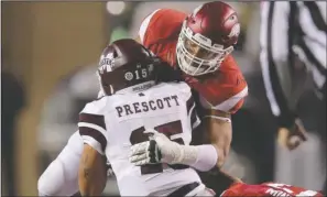 ??  ?? WORD TO THE WISE: Arkansas defensive lineman Deatrich Wise Jr. slows Dak Prescott on this play, something the Razorbacks could not do often in the first half Saturday night in Fayettevil­le. Prescott accounted for four touchdowns as Mississipp­i State...