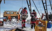  ?? SERGEY PONOMAREV/THE NEW YORK TIMES ?? Scientists register a light-detecting sphere, one of 36 to be submerged 2,300 feet below the surface of Lake Baikal in Russia, on March 1.