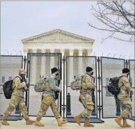  ??  ?? Members of the National Guard walk outside of the US Supreme Court, during the impeachmen­t trial of former president Donald Trump at the Capitol in Washington.