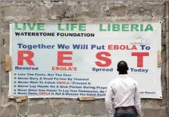  ??  ?? A man reads an Ebola awareness poster outside the closed Médecins Sans Frontières Ebola treatment unit in Paynesvill­e, outside Monrovia, Liberia.