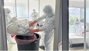  ?? DEPARTMENT OF DISEASE CONTROL ?? A team of provincial health officials clean a condominiu­m in Phuket where the country’s first recorded case of monkeypox was found on July 22.