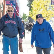  ??  ?? FALL CLASSIC FEVER: Mike Davison of Foxboro and Rich Buhrke of Chicago walk down Jersey Street yesterday.