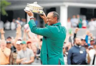  ?? JUSTIN LANE / EFE ?? Tiger Woods, con la chaqueta verde, celebra su triunfo en Augusta.