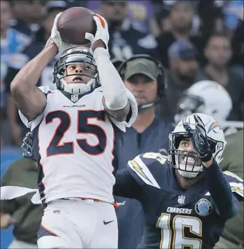  ?? Robert Gauthier Los Angeles Times ?? IN WHAT was a familiar sight, Broncos cornerback Chris Harris Jr. intercepts a pass intended for the Chargers’ Tyrell Williams in 2018. Harris signed with the Chargers after nine seasons with Denver.