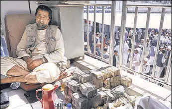  ?? REUTERS ?? An Afghan money exchange dealer waits for customers after banks and markets reopened.