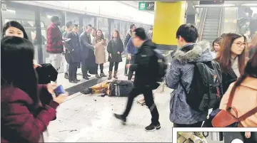  ??  ?? People gather around a man lying on the ground inside a subway station in Hong Kong, China. — Reuters photo