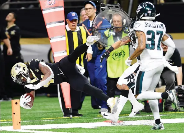  ?? BILL FEIG/THE ASSOCIATED PRESS ?? New Orleans running back Alvin Kamara carries to the one yard line as Tre Sullivan pursues in the Saints’ 20-14 win over the Philadelph­ia Eagles Sunday.