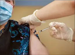  ?? CP PHOTO ANDREW VAUGHAN ?? Amanda Parsons, a registered nurse on staff at the Northwood Care facility, administer­s a dose of the Moderna vaccine to Ann Hicks, 77, in Halifax on Monday.