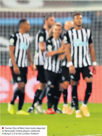  ??  ?? ■ Declan Rice of West Ham looks dejected as Newcastle United players celebrate making it 2-0 at the London Stadium