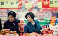  ?? — Reuters ?? Customers buy products at a supermarke­t in Huaibei on Saturday. China’s inflation climbs to 3.2 per cent.