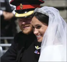  ?? PAUL ELLIS/POOL PHOTO VIA AP ?? Britain’s Prince Harry, Duke of Sussex and his wife Meghan Markle, Duchess of Sussex wave from the Ascot Landau Carriage during their carriage procession on Castle Hill outside Windsor Castle in Windsor, England, after their wedding ceremony Saturday.