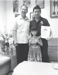  ??  ?? GEMBIRA:Cherylmenu­njukkan MyKID ditemani ayahnya, Yap dan Datuk Sebastian Ting (kiri) di SUPP Piasau semalam.