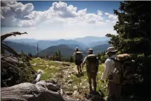  ?? MAX WHITTAKER / THE NEW YORK TIMES ?? From left: Veterans Heath Lanctot, Jeremy Tierney and John French near Berthoud Pass July 8 in Colorado during their 3,100-mile hike of the Continenta­l Divide Trail. Many veterans turn to trekking in hopes of finding serenity in a life upended by...