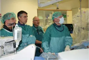  ?? (SZMC) ?? PROF. MICHAEL GLICKSON (right) and his colleagues watch a monitor in an operating room at Shaare Zedek Medical Center.