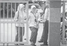  ?? Alexandra Radu / Associated Press ?? Medical staff leave the forensic department at Kuala Lumpur Hospital in Malaysia on Saturday. The body of Kim Jong Nam, who died on Monday in that nation, is guarded there.