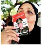  ??  ?? A supporter of of Egypt's new President Abdel Fattah al-Sisi kisses his picture in Cairo
