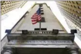  ?? RICHARD DREW — THE ASSOCIATED PRESS FILE ?? In this Friday file photo, the American flag flies above the Wall Street entrance to the New York Stock Exchange. Wall Street closed out the final day of the second quarter with slight gains after a broad rally faded in the last few minutes of trading...