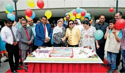  ??  ?? Amal Galal Sabry, Hjayceelyn Quintana and others cut a cake during an autism awareness campaign at Mushrif Mall.