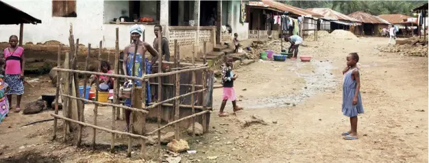  ??  ?? LIMITED BENEFITS: A woman stands at a water pump in Masumbiri, Tonkolili district, Sierra Leone