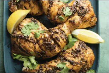  ?? MILK STREET ?? Moroccan-inspired roasted spiced chicken is richly seasoned with a mixture of cilantro, parsley, paprika, cayenne and cumin before being cooked over glowing coals.