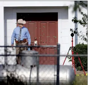  ?? AP/DAVID J. PHILLIP ?? Markers show where bullets were fired into the door at First Baptist Church in Sutherland Springs, Texas, as a law enforcemen­t officer walks out the door Tuesday. As the investigat­ion continues into the massacre of 26 people at the church, officials...