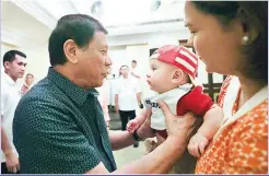  ??  ?? A LOLO’S LOVE – President Rodrigo Roa Duterte (left) takes time out from his busy schedule to carry his youngest grandson, six-month-old Marko Digong ‘Stonefish’ Duterte Carpio who is the third child of Davao City Mayor Sara Duterte Carpio (right) and...