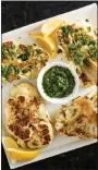  ?? COURTESY OF AMERICA’S TEST KITCHEN ?? Salsa verde tops roasted slabs of cauliflowe­r.