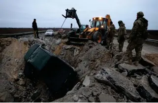  ?? AFP PHOTO ?? ENEMY EVIDENCE?
Ukrainian soldiers pull a car out of a crater on a road in the Kherson region, southern Ukraine on Sunday, Nov. 13, 2022.