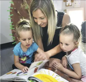  ?? ED KAISER ?? Twins Olivia, left, and Sophia Fedor, 3, participan­ts in the 100 Voices preschool program, listen to teacher Samara Berezan.