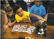  ?? Mason Trinca / Special to The Chronicle ?? Theo Turnipseed, 8, touches a droid during the educationa­l contest at Lucasfilm headquarte­rs.