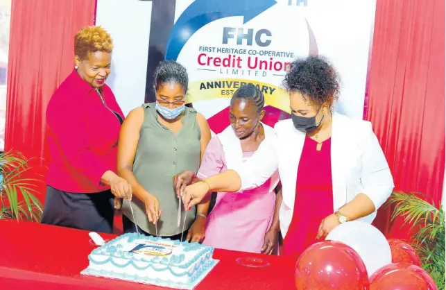  ?? ?? Roxann Linton, Chief Executive Officer (left) and Melissa Miller Benjamin, Senior Branch Manager shares in photograph with decade members during a cake cutting ceremony in commemorat­ion of FHC’S 10th Anniversar­y celebratio­ns on August 2, 2022.