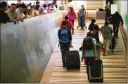  ?? JAE C. HONG / ASSOCIATED PRESS ?? Travelers walk up an arrival ramp at the Los Angeles Internatio­nal Airport Thursday. The U.S. Supreme Court approved some restrictio­ns on travel to the U.S. from six mostly Muslim nations. The new partial ban took effect Thursday night.