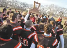 ??  ?? The Yorkton Raiders celebrate with the Moose Jaw High School Football League championsh­ip trophy.