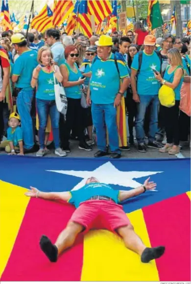 ?? ENRIC FONTCUBERT­A / EFE ?? Un hombre se tumba sobre la ‘estelada’ durante la manifestac­ión independen­tista celebrada ayer en Barcelona.