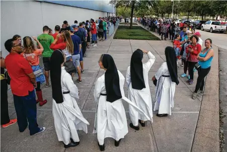  ?? Michael Ciaglo / Houston Chronicle ?? A quartet of Dominican sisters from Mary Immaculate Province join a line of people waiting to volunteer at NRG Center, which opened its doors to a capacity of 10,000 evacuees in the wake of Tropical Storm Harvey on Wednesday.