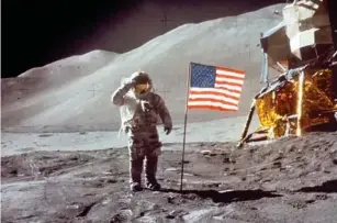  ?? (Getty) ?? Scott sa l utes the camera next to the US f l ag after l anding on the moon on 30 Ju l y 1971