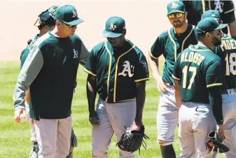  ?? Jason Miller / Getty Images ?? A’s starter Jharel Cotton (center), being removed from the game by manager Bob Melvin (left), didn’t help his cause by walking home a run during the team’s woeful sixth inning.