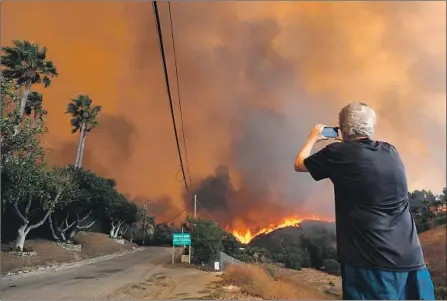  ?? Genaro Molina Los Angeles Times ?? A RESIDENT in Malibu shoots video of the Woolsey fire, which has chewed through 98,362 acres and claimed three lives.