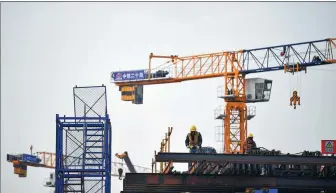  ?? ZHANG BOWEN / XINHUA ?? CREC employees work on a bridge project in Xi’an, Shaanxi province.