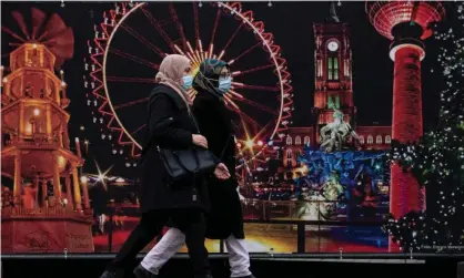  ?? Photograph: John MacDougall/AFP/Getty Images ?? Women wearing face masks walk past the site of a traditiona­l Christmas market in Berlin. The global study found that mask wearing was the most effective way to curb Covid infections.