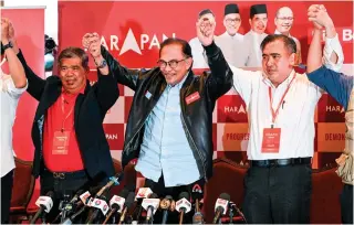  ?? AFP PHOTO ?? JUBILATION
Malaysia’s opposition leader Anwar Ibrahim (center) reacts at the end of a press conference in Kuala Lumpur on Sunday, Nov. 20, 2022.