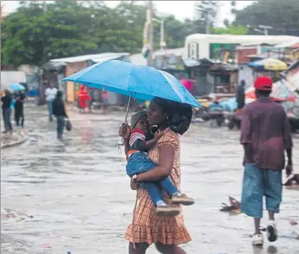  ?? DIEU NALIO CHERY / AP ?? Una mujer apresura el paso ante al llegada del Matthew y en Puerto Príncipe (Haití)