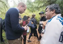  ?? JONATHAN HAYWARD, THE CANADIAN PRESS ?? The Duke and Duchess of Cambridge greet a young First Nations boy following a ceremony in the Great Bear Rainforest in Bella Bella on Monday.