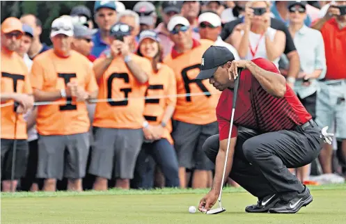  ??  ?? Crowd-puller: Enthusiast­ic fans look on as Tiger Woods lines up a putt in Tampa