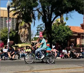  ?? RECORDER PHOTO BY ESTHER AVILA ?? With a colorful piñata as a passenger in the back of the Portervill­e Library Junction tricycle, a man rides down Main Street Saturday during the CHMA Cinco de Mayo Parade.