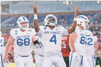  ?? JEFFREY MCWHORTER/ASSOCIATED PRESS ?? Air Force quarterbac­k Haaziq Daniels, center, celebrates a touchdown run against Louisville as offensive tackle Mark Heistand, left, looks on during the First Responder Bowl on Tuesday in Dallas.